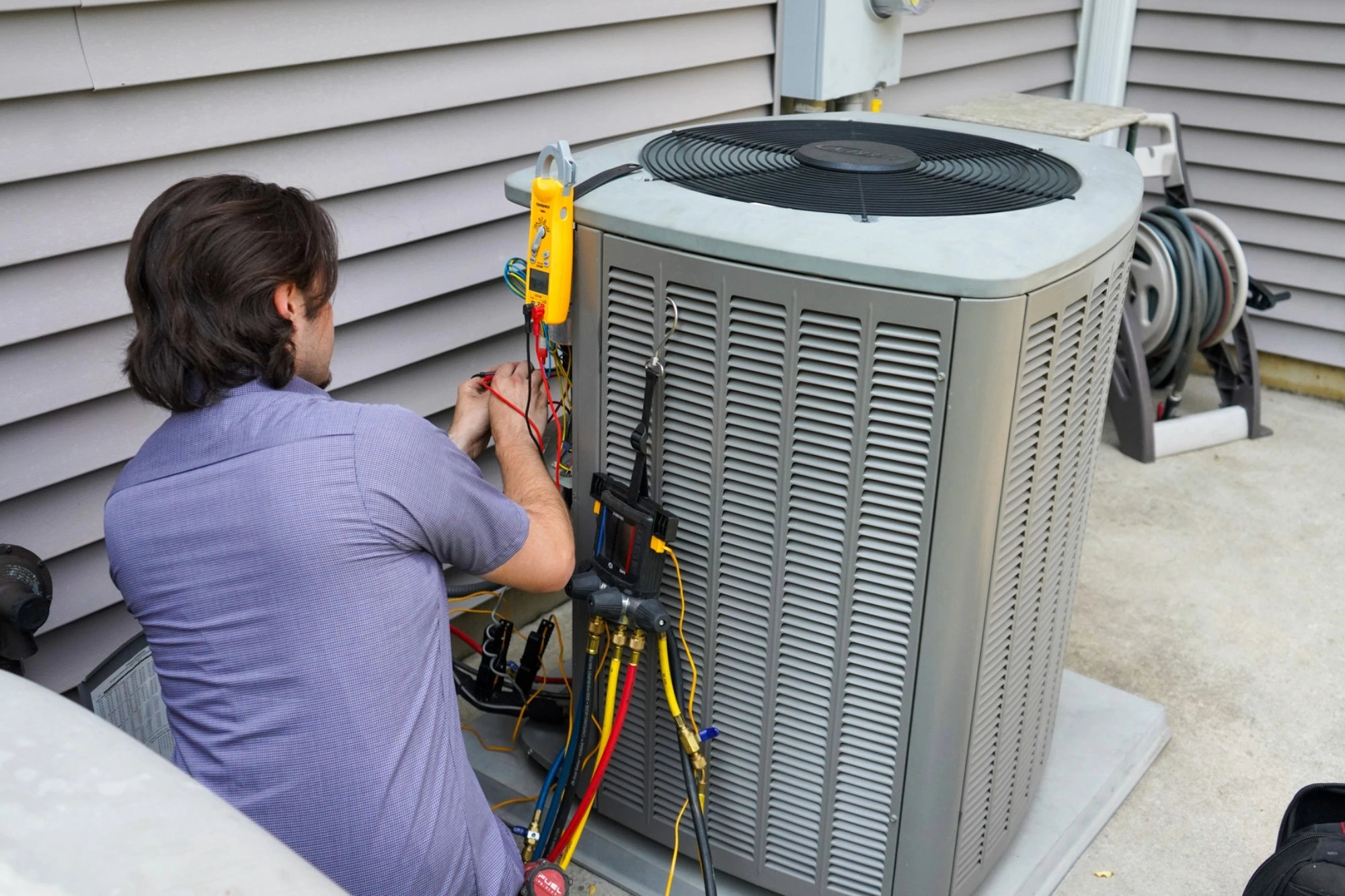 HVAC technician servicing an outdoor central air unit