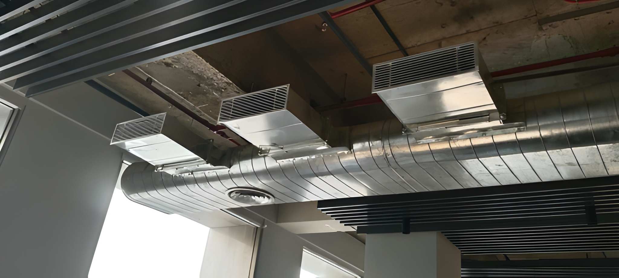 Exposed ductwork with multi-outlet rectangular grilles and bottom swirl diffuser